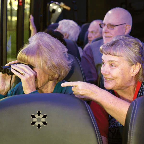 Retired individuals on a bus looking through binoculars!